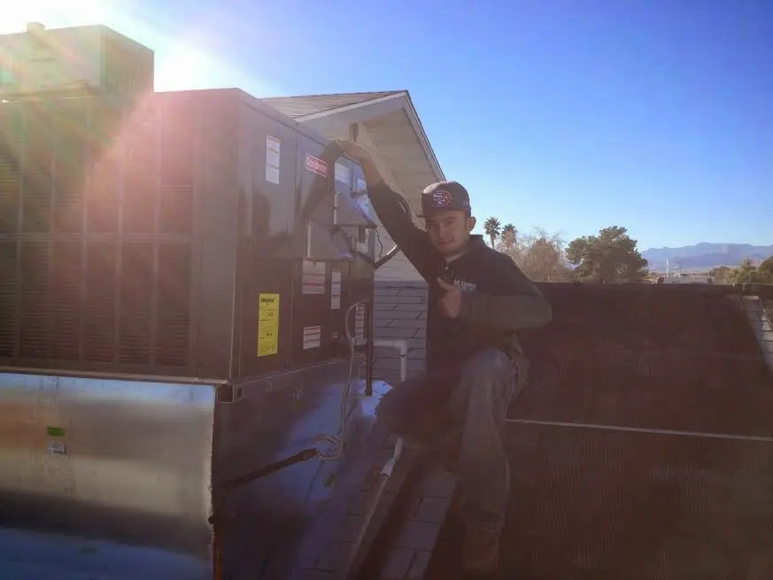 HVAC technician performing Boiler Repair on a rooftop unit in Monaca